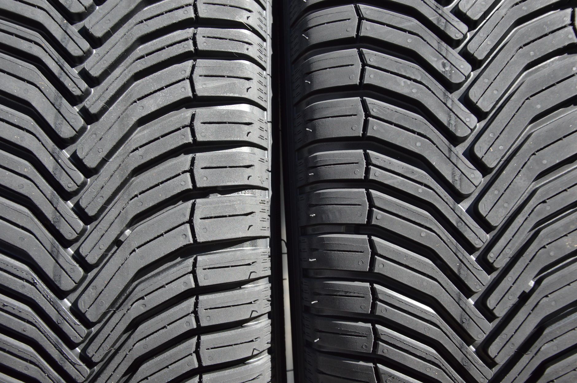 Close-up comparison of semi-slick track tyre versus road tyre tread pattern