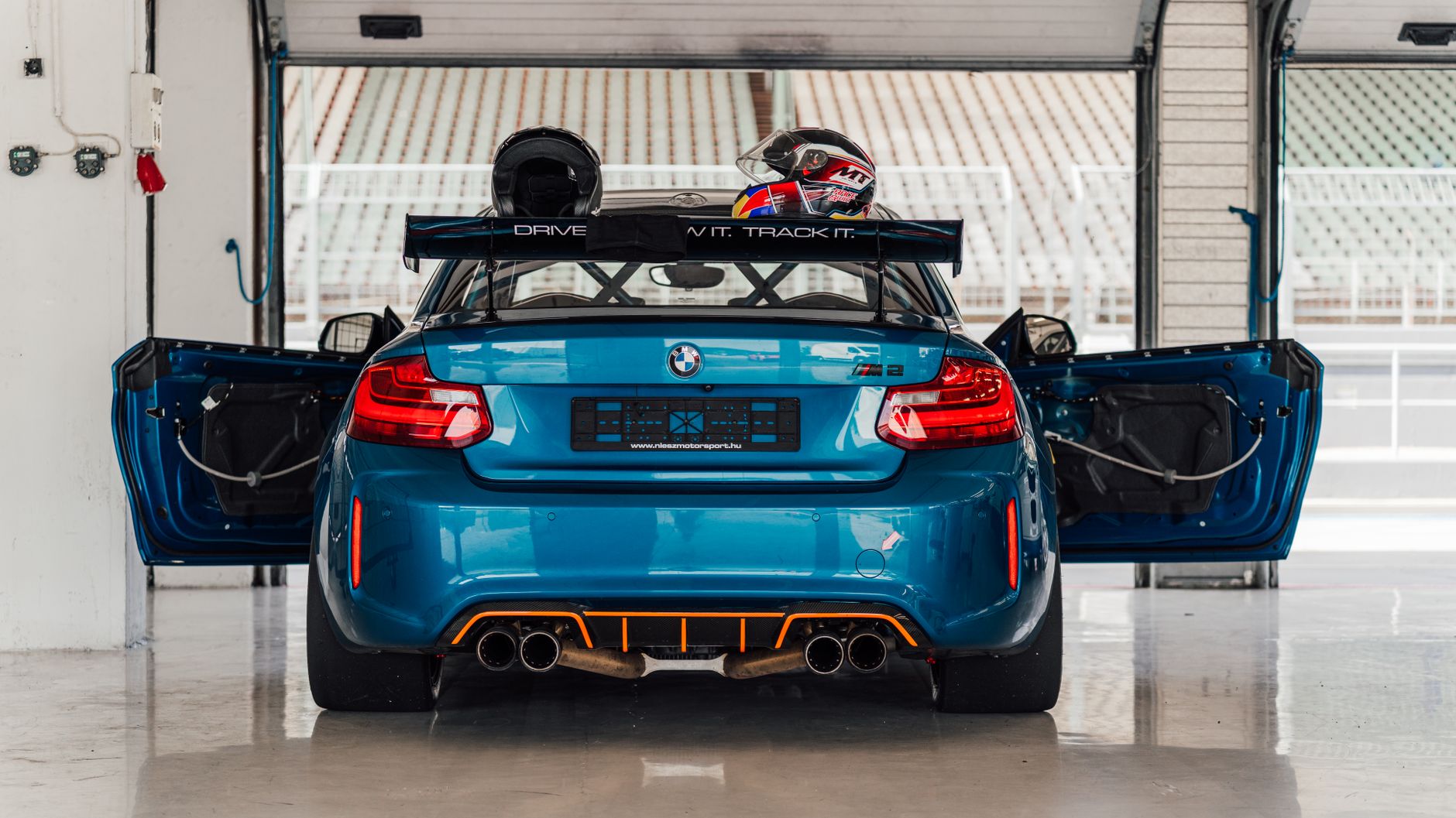 Used BMW M2 Competition driving on a UK road in Long Beach Blue